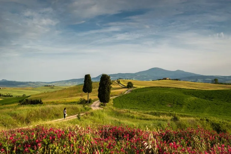 Vrouw wandelt in een Toscaans landschap